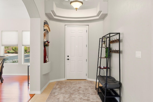 tiled entryway with a raised ceiling