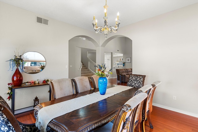 dining space featuring hardwood / wood-style flooring and a chandelier