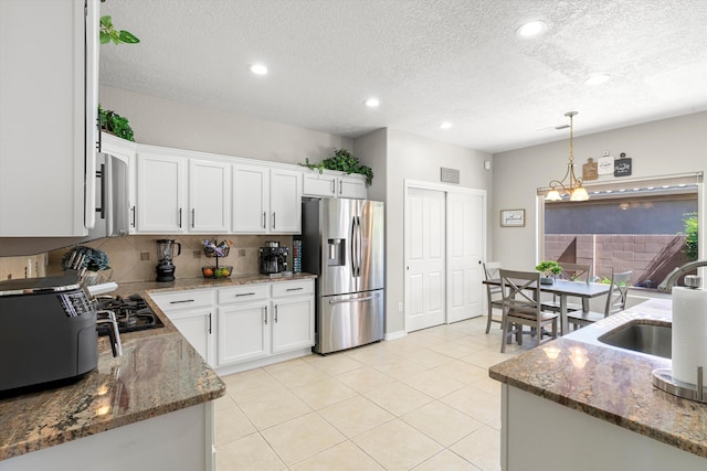 kitchen featuring white cabinetry, sink, stainless steel fridge with ice dispenser, and hanging light fixtures