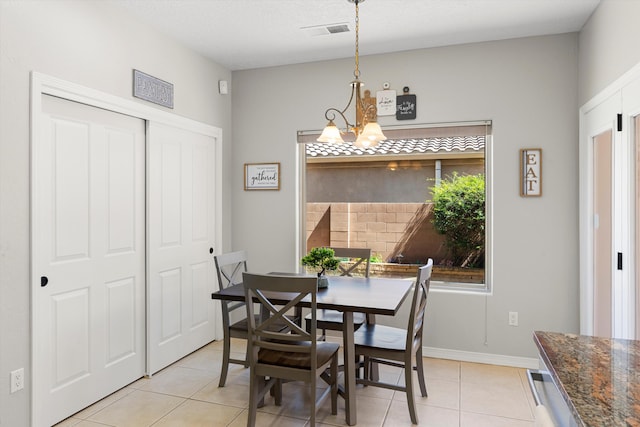 dining area with light tile patterned floors and a chandelier