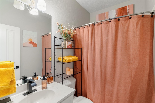 bathroom featuring vanity, a textured ceiling, and toilet