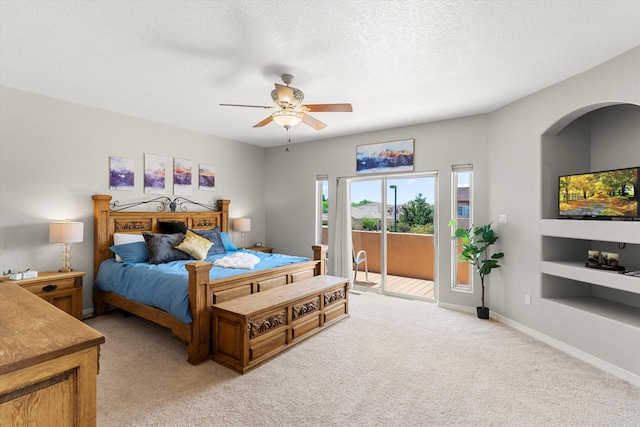 bedroom with ceiling fan, access to outside, light colored carpet, and a textured ceiling