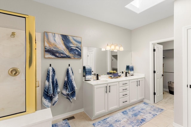 bathroom with vanity, tile patterned flooring, a skylight, and a shower