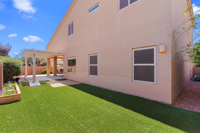 back of house featuring a lawn and a pergola