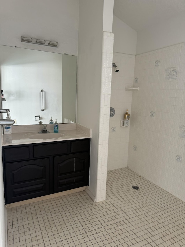 bathroom featuring a tile shower, tile patterned floors, and vanity