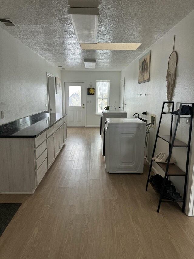 kitchen featuring light brown cabinets, light hardwood / wood-style flooring, and independent washer and dryer