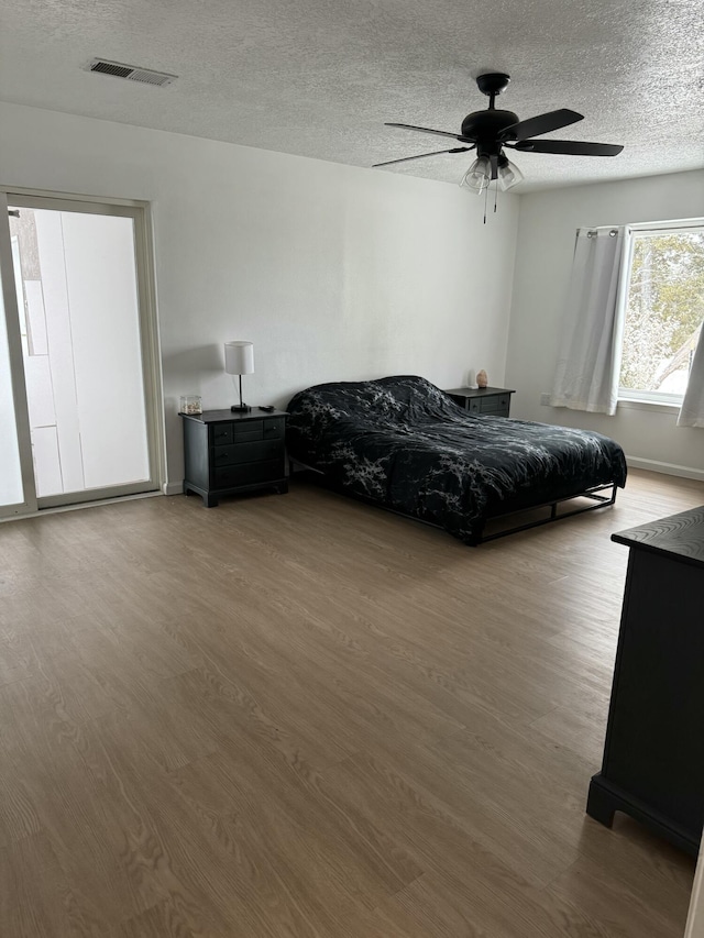 unfurnished bedroom featuring dark wood-type flooring, a textured ceiling, and ceiling fan