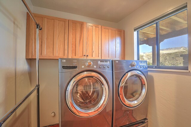 washroom featuring cabinets and washing machine and clothes dryer