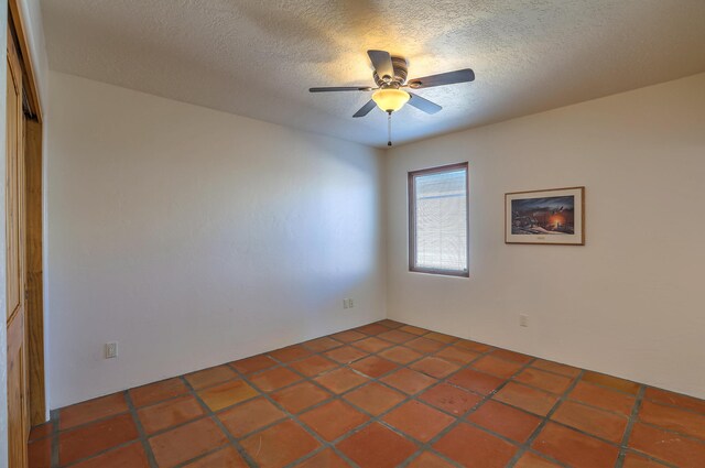 spare room featuring ceiling fan and a textured ceiling