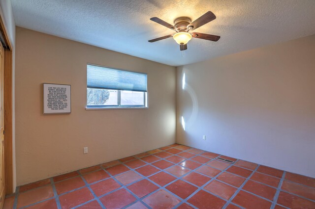 unfurnished room featuring a textured ceiling, ceiling fan, and tile patterned floors