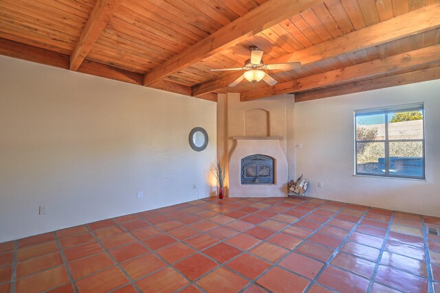 unfurnished living room featuring ceiling fan, wooden ceiling, and beamed ceiling