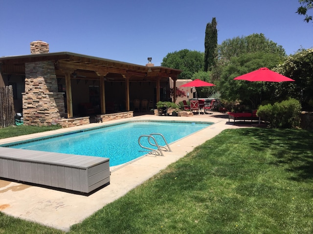 view of swimming pool featuring a patio area and a lawn