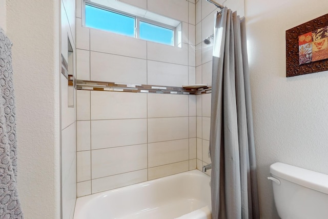 bathroom featuring shower / tub combo with curtain and toilet