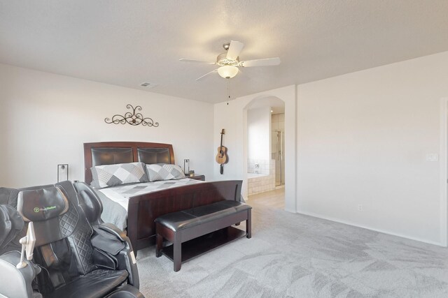 carpeted bedroom with connected bathroom and ceiling fan