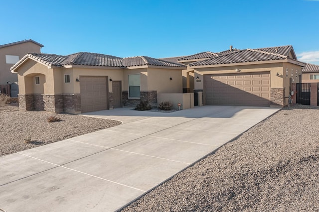 view of front of property with a garage, stone siding, concrete driveway, and stucco siding