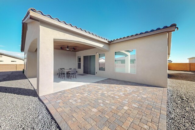 rear view of property featuring ceiling fan and a patio