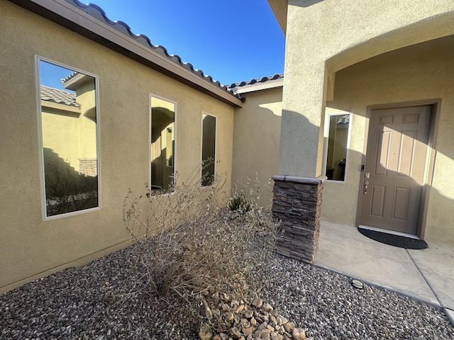 view of exterior entry featuring a patio area