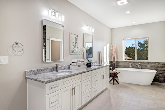 bathroom with a washtub, tile walls, tile patterned floors, and vanity