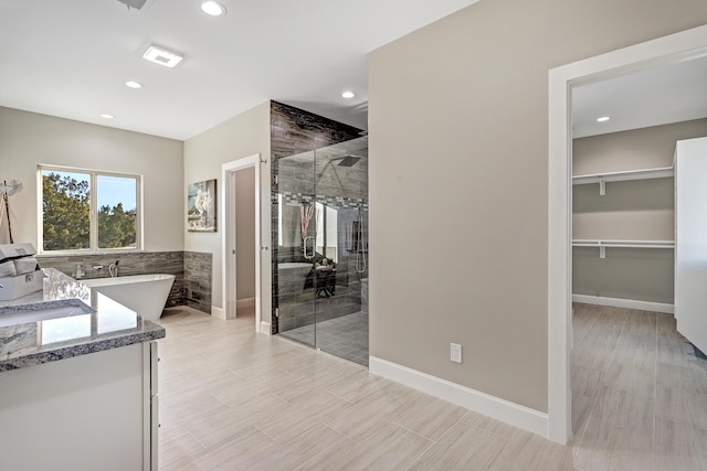 bathroom with independent shower and bath and vanity