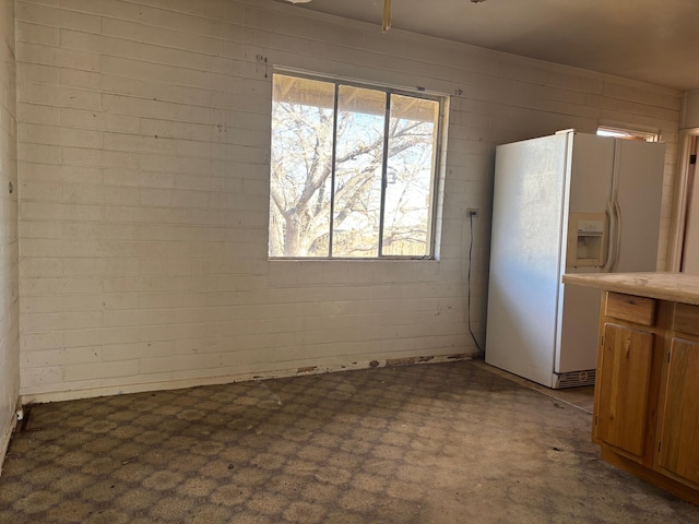 unfurnished dining area featuring brick wall