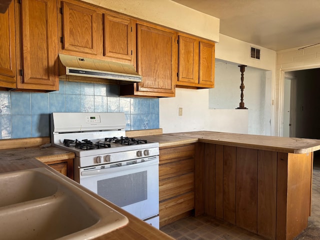 kitchen featuring white gas range and kitchen peninsula