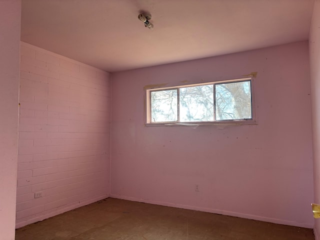 unfurnished room with brick wall