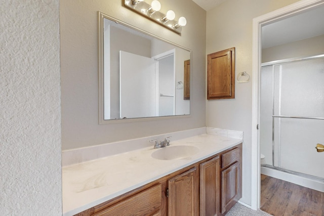 bathroom with vanity, toilet, wood-type flooring, and walk in shower