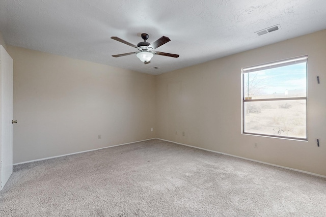 carpeted empty room featuring ceiling fan and a textured ceiling