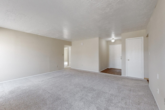 empty room featuring a textured ceiling and carpet