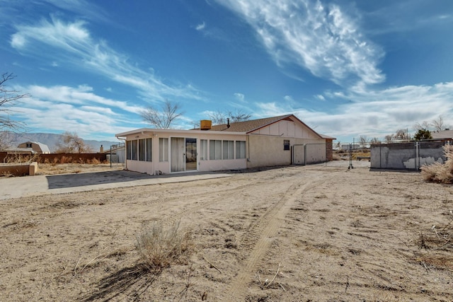 rear view of property featuring a sunroom