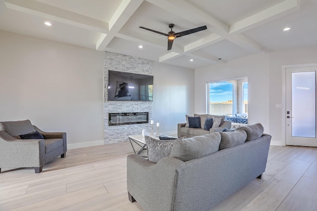 living room with ceiling fan, beam ceiling, a fireplace, and coffered ceiling