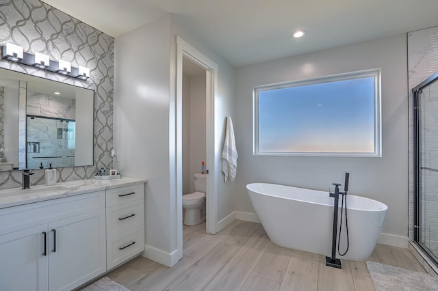 full bathroom featuring toilet, separate shower and tub, and vanity