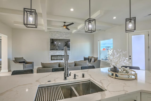 kitchen with sink, coffered ceiling, and decorative light fixtures