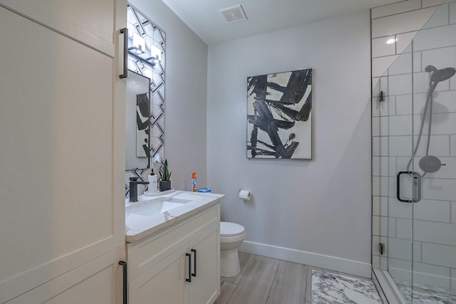 bathroom with wood-type flooring, toilet, vanity, and an enclosed shower