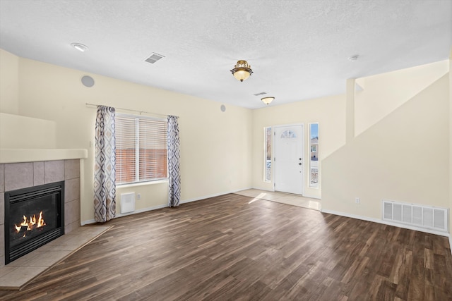 unfurnished living room featuring a textured ceiling, a fireplace, and hardwood / wood-style floors