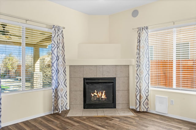 details featuring a tile fireplace and hardwood / wood-style flooring