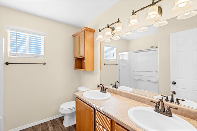 bathroom with an enclosed shower, vanity, toilet, and hardwood / wood-style floors