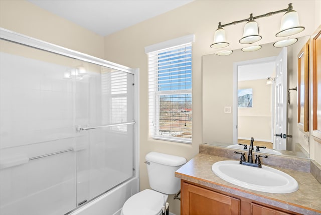 full bathroom featuring toilet, bath / shower combo with glass door, and vanity