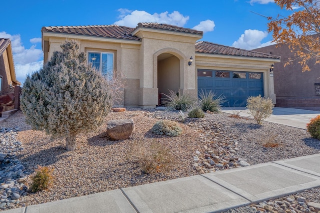 mediterranean / spanish-style house with driveway, an attached garage, a tile roof, and stucco siding