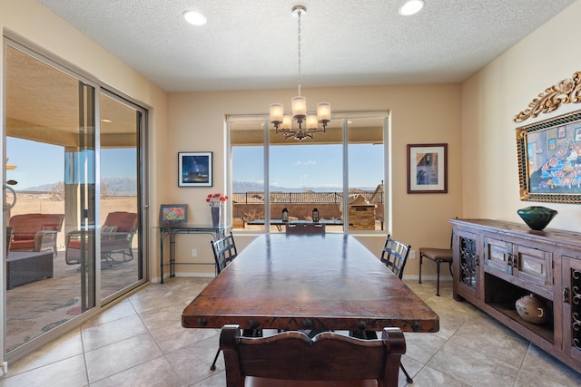 dining area with light tile patterned flooring, a textured ceiling, and an inviting chandelier