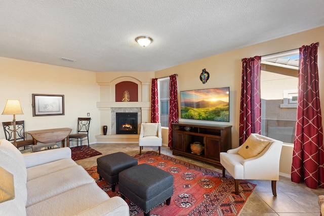 tiled living room featuring a tiled fireplace and a textured ceiling