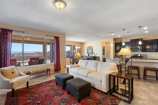 tiled living room featuring a chandelier and a textured ceiling