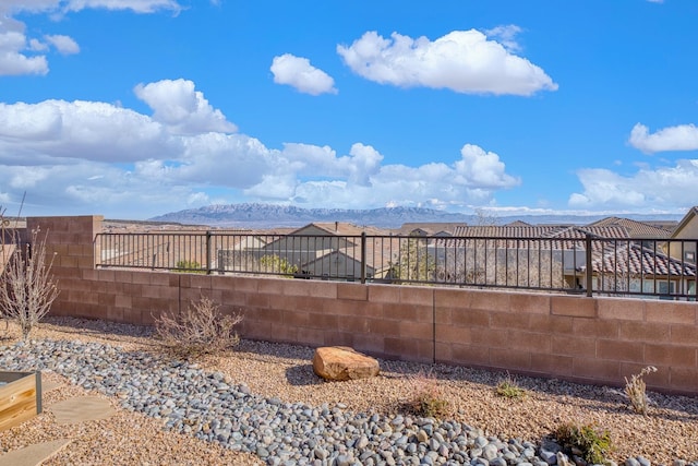 view of yard featuring fence and a mountain view