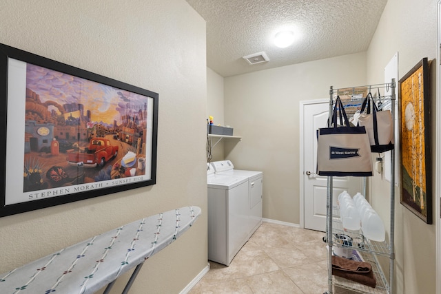 laundry room featuring visible vents, washing machine and dryer, a textured ceiling, laundry area, and baseboards