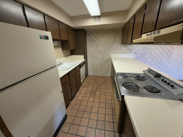 kitchen featuring sink, white appliances, and dark brown cabinets