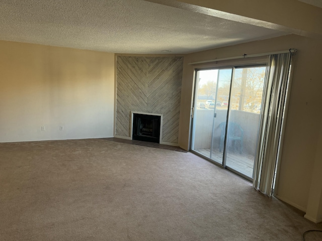 unfurnished living room featuring carpet floors, a fireplace, and a textured ceiling