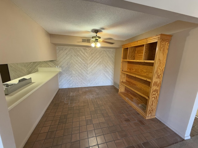 corridor with a textured ceiling and wood walls