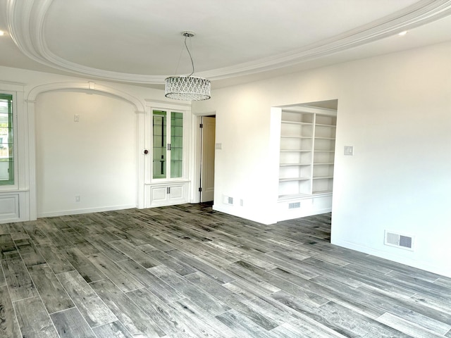 unfurnished dining area with built in shelves and dark hardwood / wood-style flooring