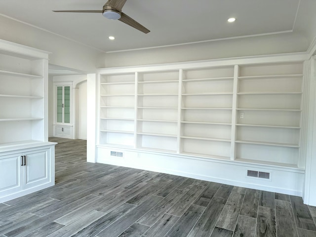 interior space with ceiling fan, dark hardwood / wood-style floors, and built in features