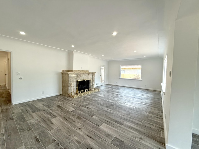 unfurnished living room featuring hardwood / wood-style flooring and a premium fireplace